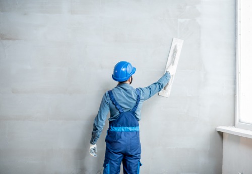 Plastering Contractors in Peoria IL plastering a business's wall